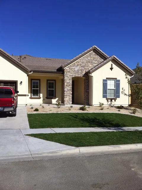 Stucco and stone craftsman home, concealed dark gutter on tile roof