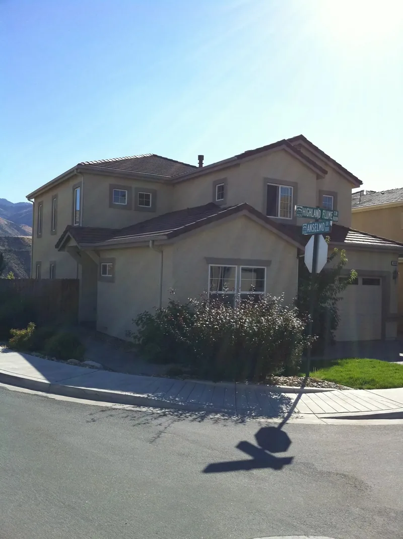 Two-story stucco on Highland Flume corner lot, tight tile-to-gutter transition
